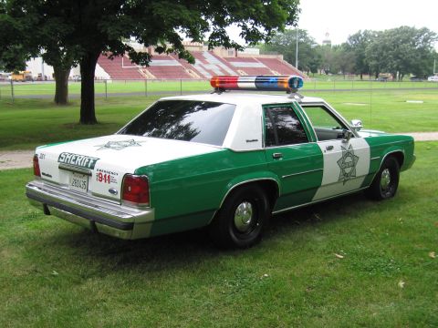 1991 Ford Crown Victoria - This Sheriff's patrol car is parked on a grassy field, with a stadium visible in the background.