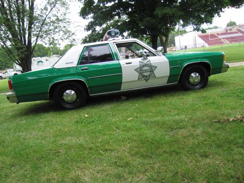 1991 Ford Crown Victoria - Side view of a two-tone green and white police car marked as 'SHERIFF'.