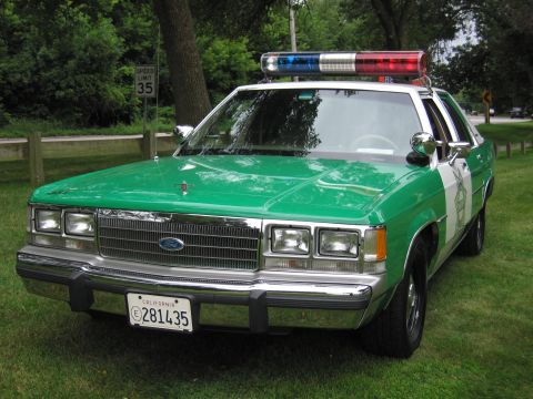 1991 Ford Crown Victoria - This 1991 Ford Crown Victoria police car features a distinctive green and white livery and a light bar on the roof.