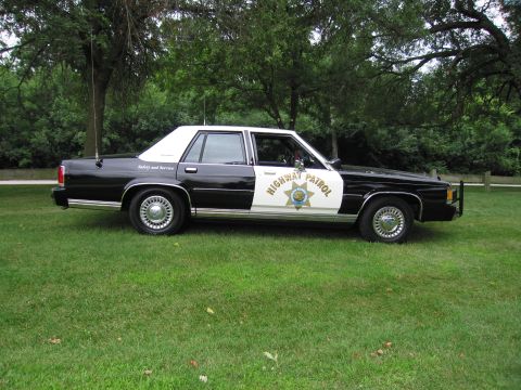 1991 Ford Crown Victoria - This 1991 Ford Crown Victoria, marked as a highway patrol vehicle, is seen from the side on a grassy area.