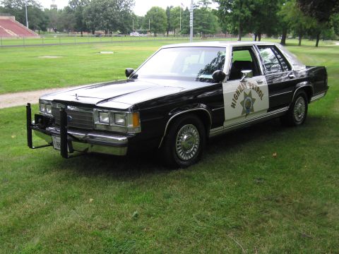 1991 Ford Crown Victoria - This 1991 Ford Crown Victoria, marked as highway patrol, features a distinctive black and white paint scheme and a front push bar.