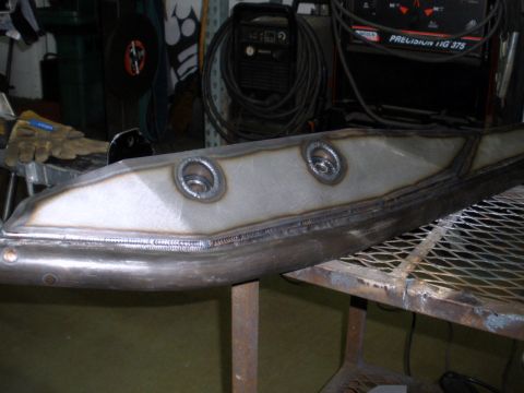 1995 Ford Bronco - A close-up view of a fabricated metal part with visible welds and circular mounting points.