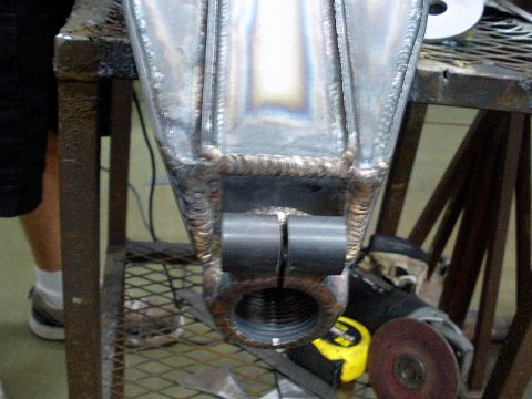 1995 Ford Bronco - Close-up of a fabricated metal suspension component, likely a trailing arm, showing extensive welding and mounting points.