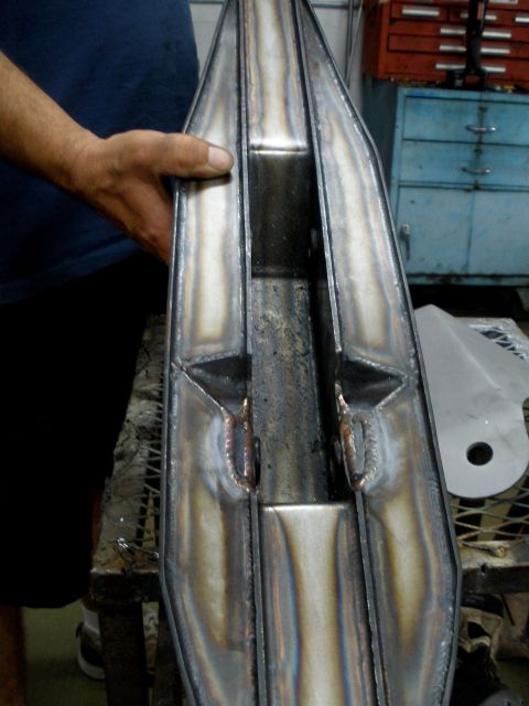 1995 Ford Bronco - Custom fabricated metal part with visible welds, held by a person's hand in a workshop.