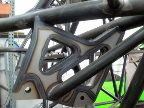 1995 Ford Bronco - Close-up of a custom-fabricated suspension bracket, likely for off-road or racing applications, showing detailed metalwork.