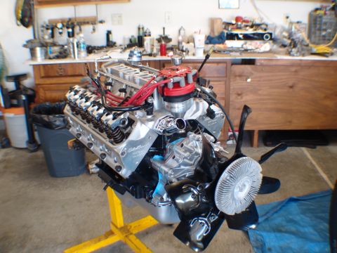 1996 Ford Bronco - Engine assembly on a yellow stand in a garage setting, showing the fan and distributor cap.
