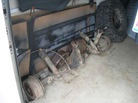 1991 Jeep Wrangler - Front and rear axles with shocks and brake drums are stored indoors, possibly for a Jeep Wrangler D60 swap.
