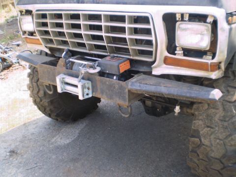 1978 Ford Bronco - The front grille and bumper of a modified Ford Bronco are shown, a winch and large off-road tires.