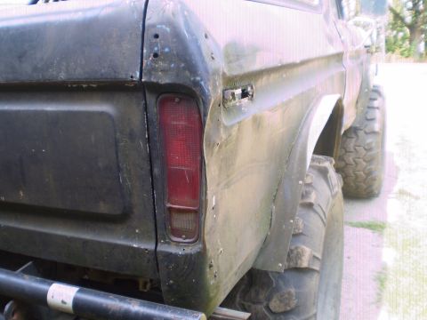 1978 Ford Bronco - Rear view of a 1978 Ford Bronco showing the quarter panel and a large off-road tire.
