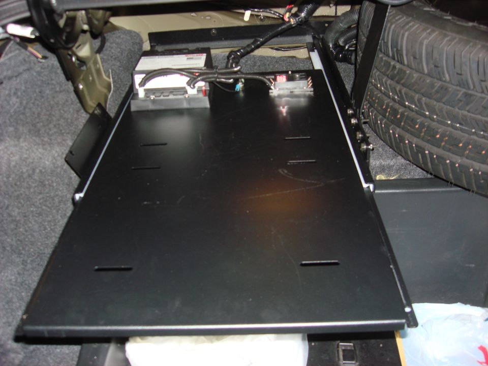 Spare tire and electronic modules visible in the trunk of a vehicle