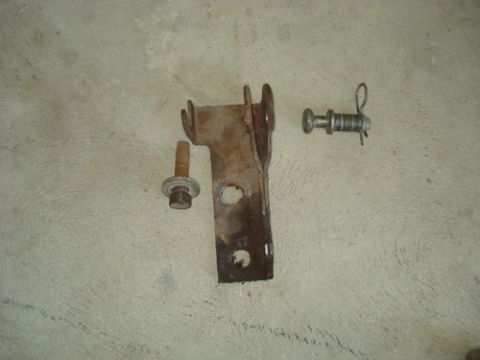 1990 Ford Bronco - Metal bracket and hardware shown on a concrete floor.