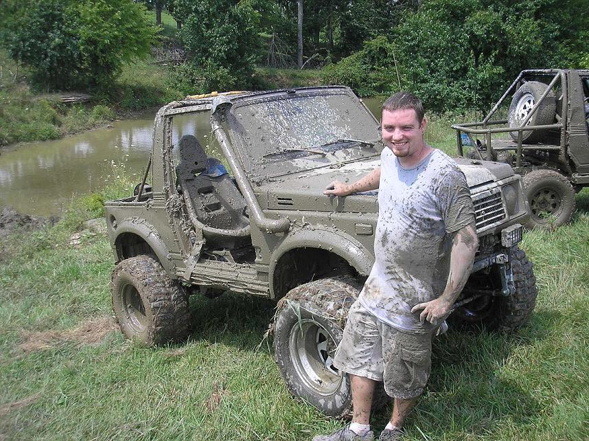 Guy next to a muddy 1987 Suzuki Samurai, another one behind it
