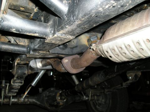 1986 Toyota Hilux - Undercarriage view showing the exhaust system and rear axle of a vehicle. A watermark reads SUPERMOTORS.