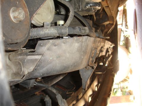 1991 Ford Taurus - The photo shows a close-up view of the undercarriage of a vehicle, revealing worn metal components and wiring.