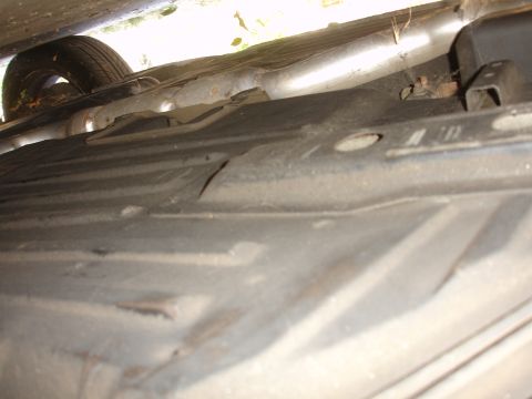1991 Ford Taurus - Underside view of a car's exhaust system and spare tire.