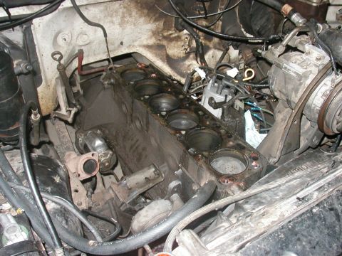1990 Ford Taurus - Engine block with cylinders exposed, distributor, and hoses visible.