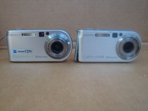 1993 Ford Taurus - Two silver Sony Cyber-shot digital cameras are displayed side-by-side against a neutral background.
