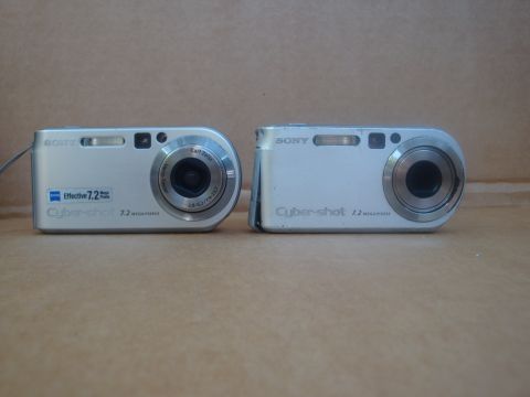 1993 Ford Taurus - Two silver Sony Cyber-shot digital cameras are displayed side-by-side against a neutral background.