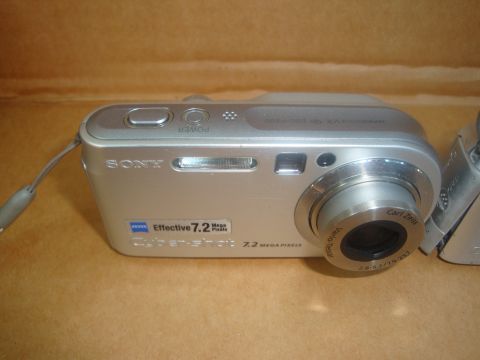 1993 Ford Taurus - A close-up view of a Sony Cyber-shot digital camera, its lens and branding.