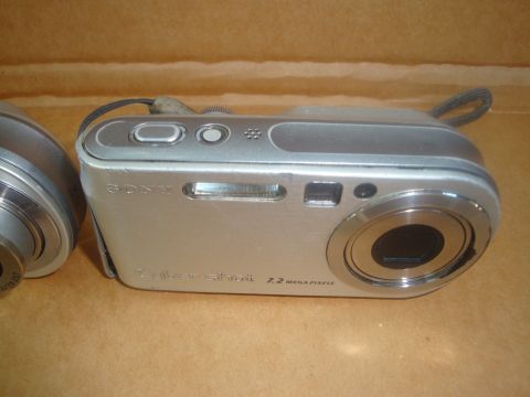 1993 Ford Taurus - A silver Sony Cyber-shot digital camera is shown with its lens and buttons visible.