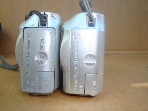 1993 Ford Taurus - A close-up view of the bottom and side of two digital cameras, highlighting their memory card and power input ports.