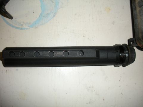 1996 Ford Bronco - Close-up of a black cylindrical automotive part with multiple holes.