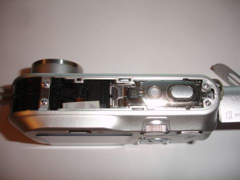 1993 Ford Taurus - Close-up view of the internal workings of a silver digital camera, revealing its electronic components.