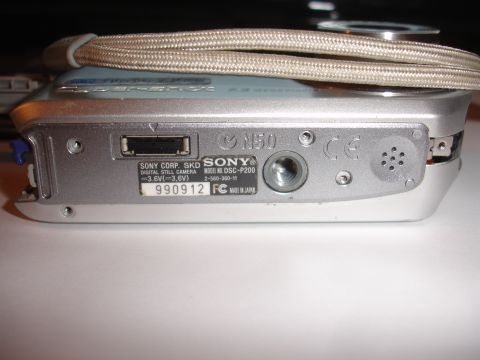1993 Ford Taurus - Bottom view of a Sony DSC-P200 digital camera, showing a USB port and product information label.