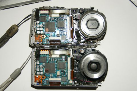 1993 Ford Taurus - Two digital cameras are shown disassembled, revealing their intricate internal components and lenses.