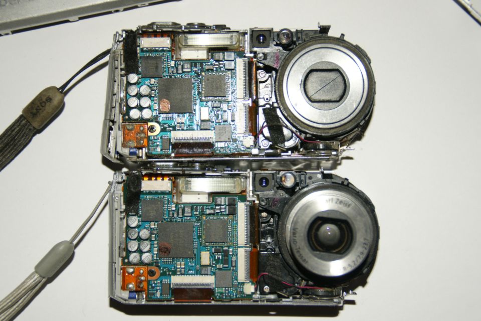 Two disassembled digital cameras showing internal circuit boards and lenses