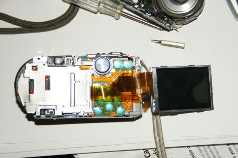 1993 Ford Taurus - A digital camera is disassembled, revealing its internal components and tools used for repair.