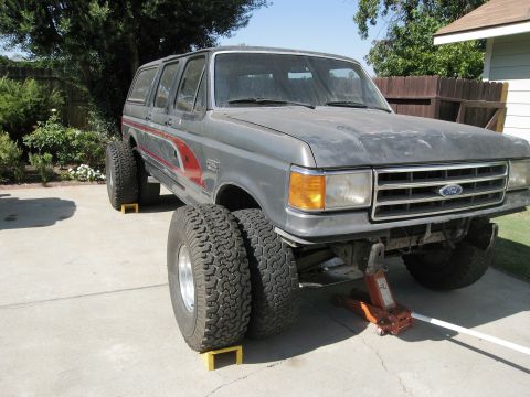 1986 Ford Bronco - This Ford truck, likely from the late 1980s, is equipped with massive tires and dual rear wheels.