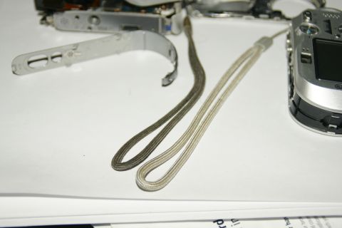 1993 Ford Taurus - Camera parts and wrist straps are laid out on a white surface.