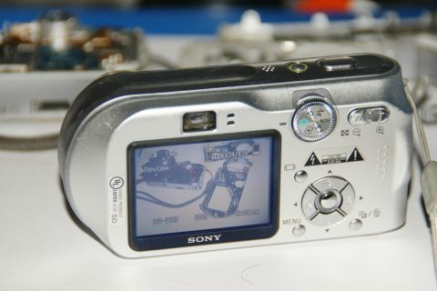 1993 Ford Taurus - A Sony digital camera is shown from the back, displaying a review of its internal electronic components on the screen.