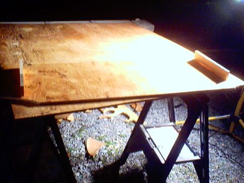 1999 Ford Taurus - A piece of plywood rests on sawhorses, illuminated by artificial light, with a Supermotors.net watermark visible.