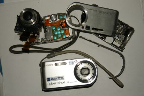 1993 Ford Taurus - Two Sony Cyber-shot digital cameras, one disassembled and one intact, are laid out on a surface.