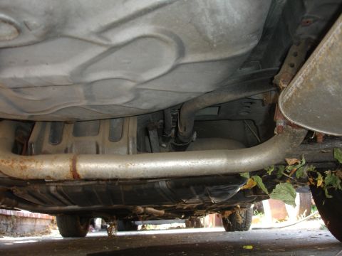 1991 Ford Taurus - Underside view of a car's undercarriage, revealing the exhaust system and fuel tank.