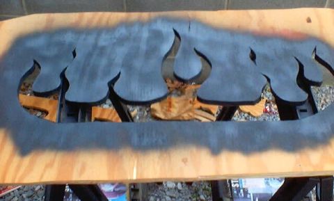1999 Ford Taurus - A wooden board with flame cutouts reveals a bull's head and horns, not a 1999 Ford Taurus.