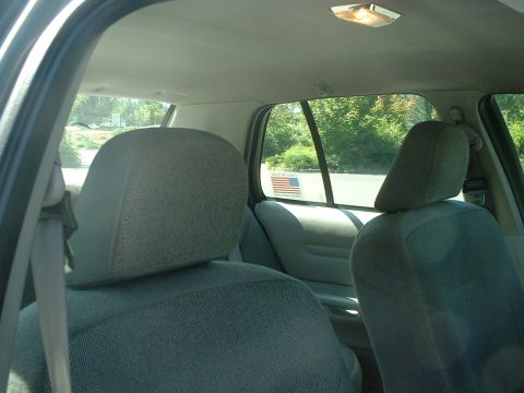 2000 Ford Crown Victoria - View from the back seat looking forward, showing the interior of a car with an American flag sticker on the window.