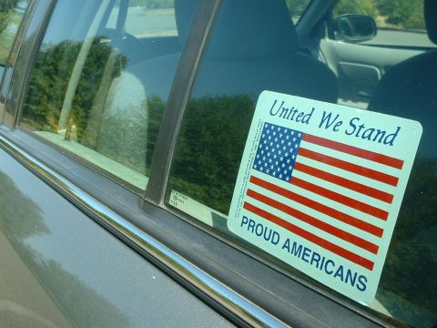 2000 Ford Crown Victoria - A sticker with the American flag is affixed to the side window of a car.