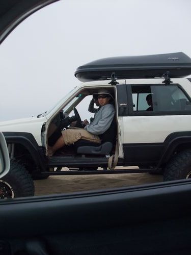 1985 Toyota 4Runner - Side view of a white 1985 Toyota 4Runner with a roof cargo box and a person driving.