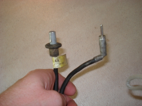 Hand holding two electrical connectors, one with a yellow tag labeled 'AA 22-16'