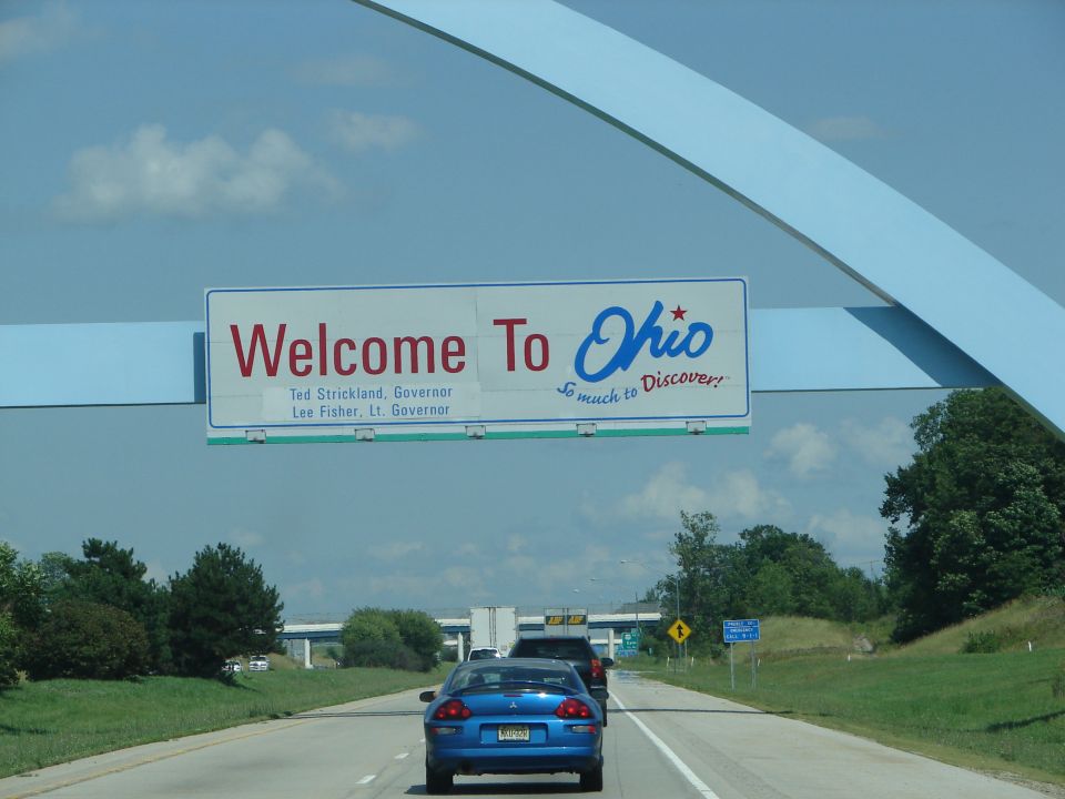 Driving on highway under Welcome to Ohio sign with governor names
