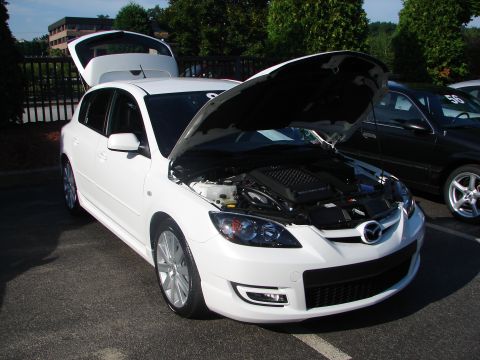 1992 Ford Taurus - A white hatchback is parked with its hood and trunk open, revealing the engine bay.