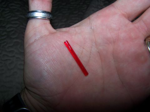 1986 Ford Bronco - Small red plastic rod held in palm with a ring on index finger.