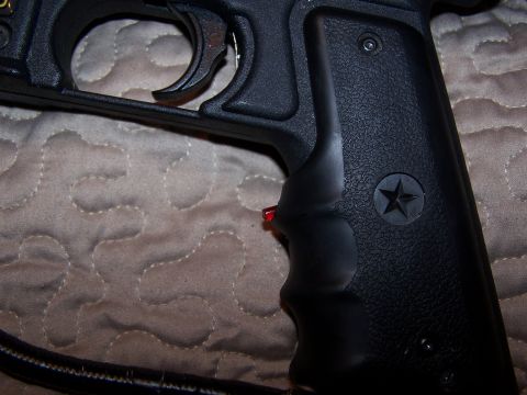 1986 Ford Bronco - Close-up view of a black gun grip with a star emblem and a red trigger safety.