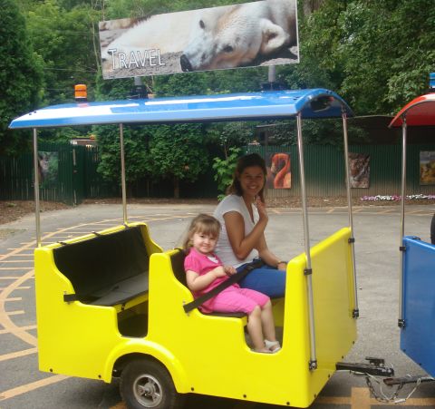 2000 Ford Crown Victoria - A woman and child ride in a yellow amusement park train car.