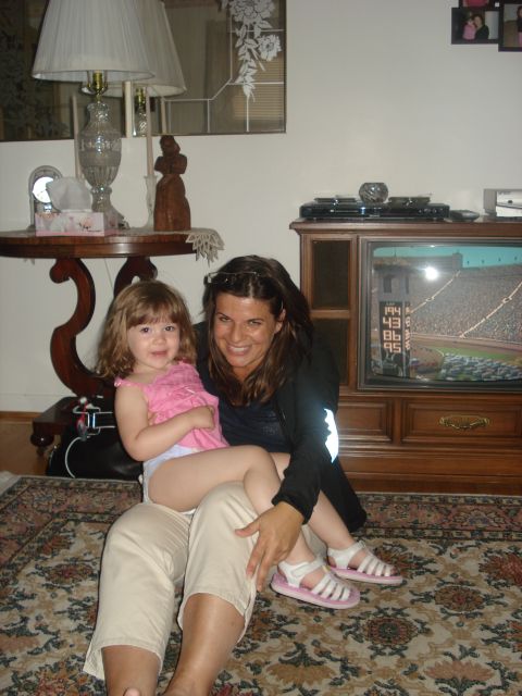 2000 Ford Crown Victoria - A woman and child enjoy a baseball game on TV in a living room setting.
