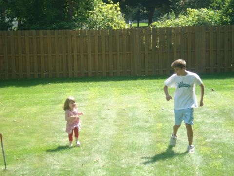 2000 Ford Crown Victoria - A boy and a young girl are playing in a backyard on a sunny day.