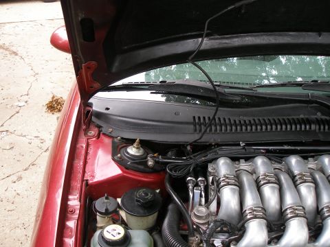 1997 Ford Taurus - Engine bay view of a 1997 Ford Taurus, highlighting the intake manifold and various fluid reservoirs.